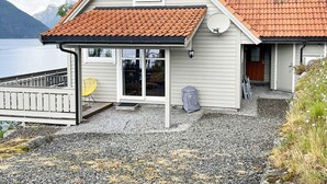A house with a sloped roof, a covered porch, and a view of a lake. - 4 Star Holiday Home in Leikanger (Sogndal)