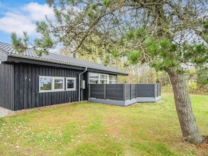 A modern house with a dark exterior, a tiled roof, and a fenced backyard. - 5 Star Holiday Home in Ebeltoft (Ebeltoft)