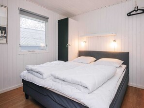 A bedroom with a bed, a window, a door, and a wall-mounted light fixture. - 8 Person Holiday Home in Orsted (Ørsted)