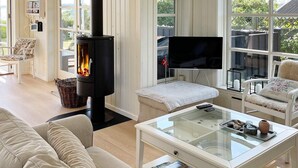 A cozy living room with a modern fireplace, comfortable seating, a glass coffee table, and a flat-screen TV. - 8 Person Holiday Home in Broager-by Traum (Broager)