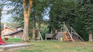 A playground with a slide, swings, and a wooden climbing structure.
