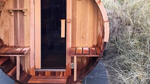 A wooden sauna with a curved exterior, a door, and a small window. - 5 Star Holiday Home in Albaek (Aalbaek)