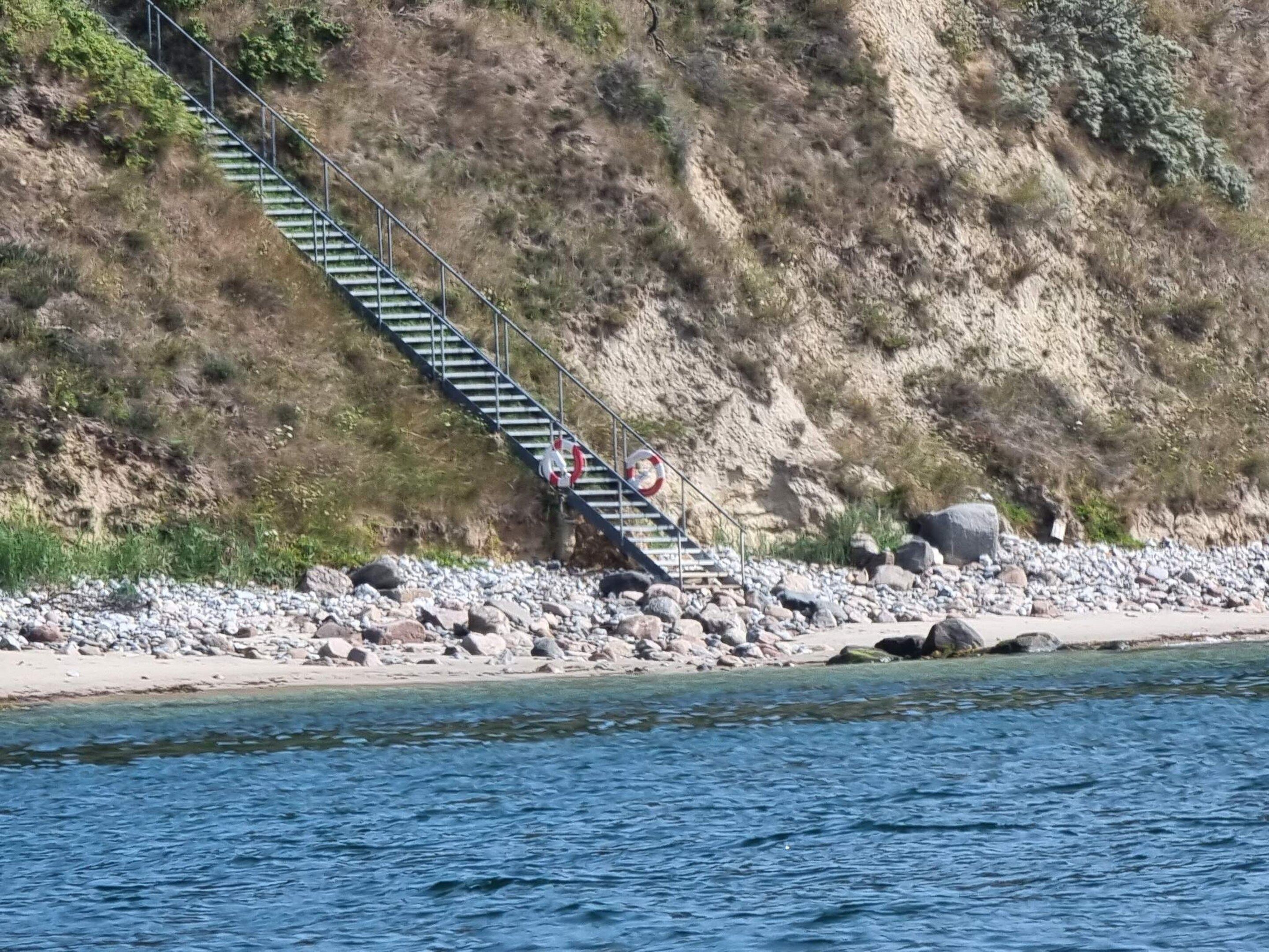 A staircase leading down to a rocky beach area.