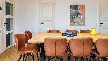 A dining area with a wooden table, six brown chairs, and a yellow vase.