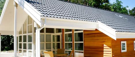 A modern house with a covered porch, large windows, and a wooden exterior.