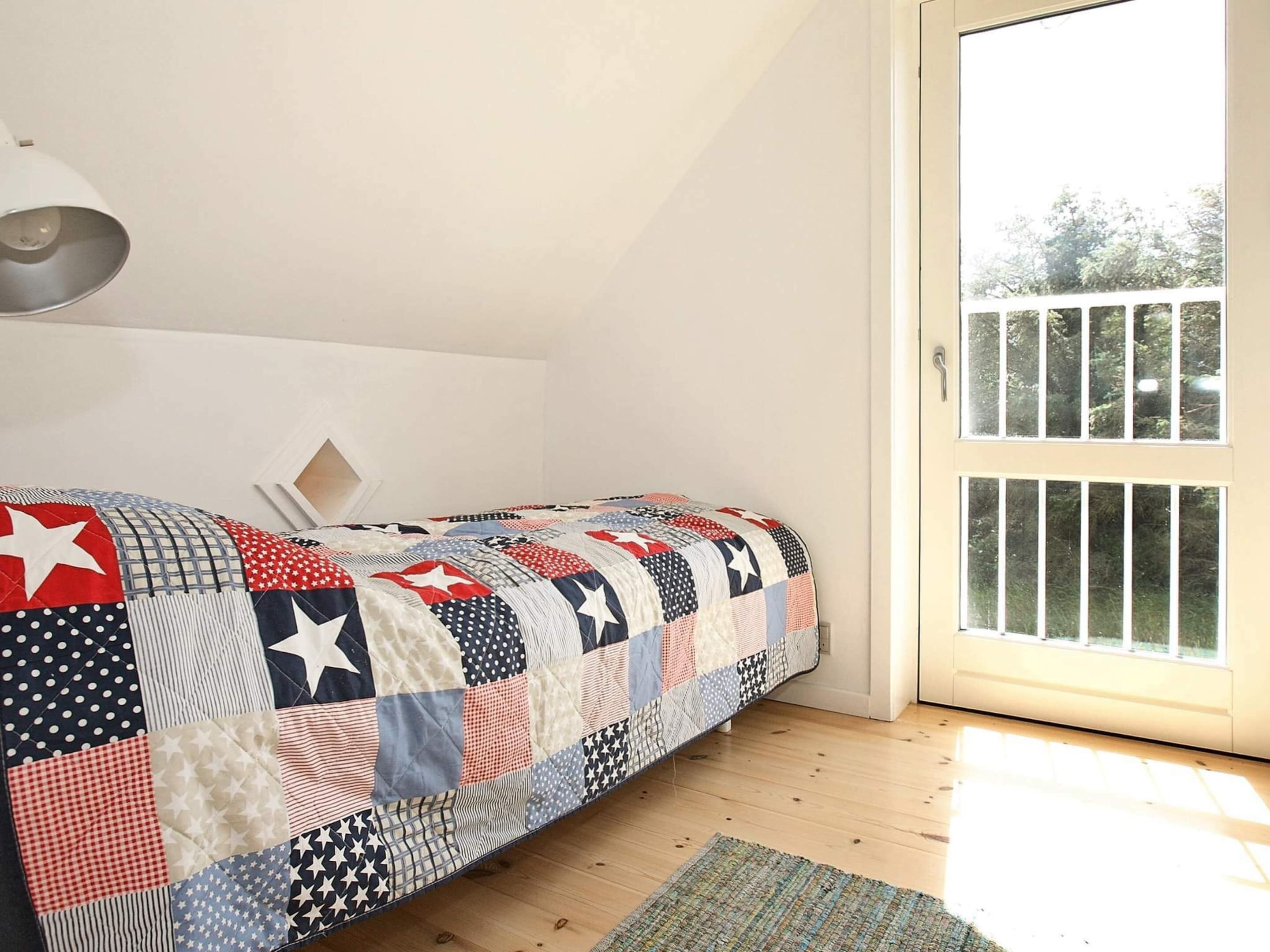 A bedroom with a bed, a window, and a door.