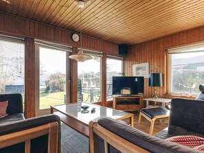 A cozy living room with a wooden ceiling, a television, a table, and comfortable seating. - Spacious Holiday Home in KarrebÃ¦ksminde near Fishing (Karrebæksminde)