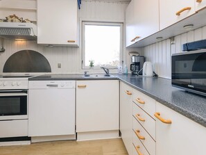 A modern kitchen with white cabinetry, a built-in oven, a dishwasher, a coffee maker, and a microwave. - Spacious Holiday Home in KarrebÃ¦ksminde near Fishing (Karrebæksminde)