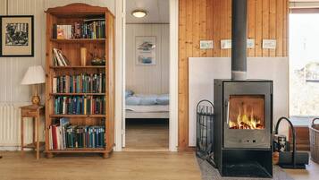 A cozy room with a wooden bookshelf, a fireplace, and a bed.