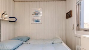 A bedroom with a bed, a nightstand, a lamp, a window, and a wall-mounted picture. - Spacious Holiday Home in KarrebÃ¦ksminde near Fishing (Karrebæksminde)