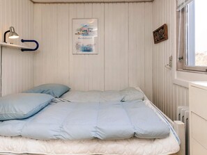 A bedroom with a bed, a nightstand, a lamp, a window, and a wall-mounted picture. - Spacious Holiday Home in KarrebÃ¦ksminde near Fishing (Karrebæksminde)