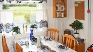 A dining area with a table set for two, featuring a floral tablecloth and star-patterned plates. - 6 Person Holiday Home in Sæbø (Orsta)