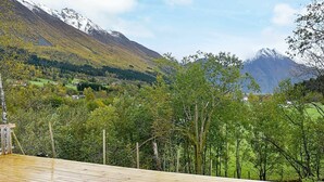 A wooden deck with a view of a mountainous landscape and a valley below. - 6 Person Holiday Home in Sæbø (Orsta)