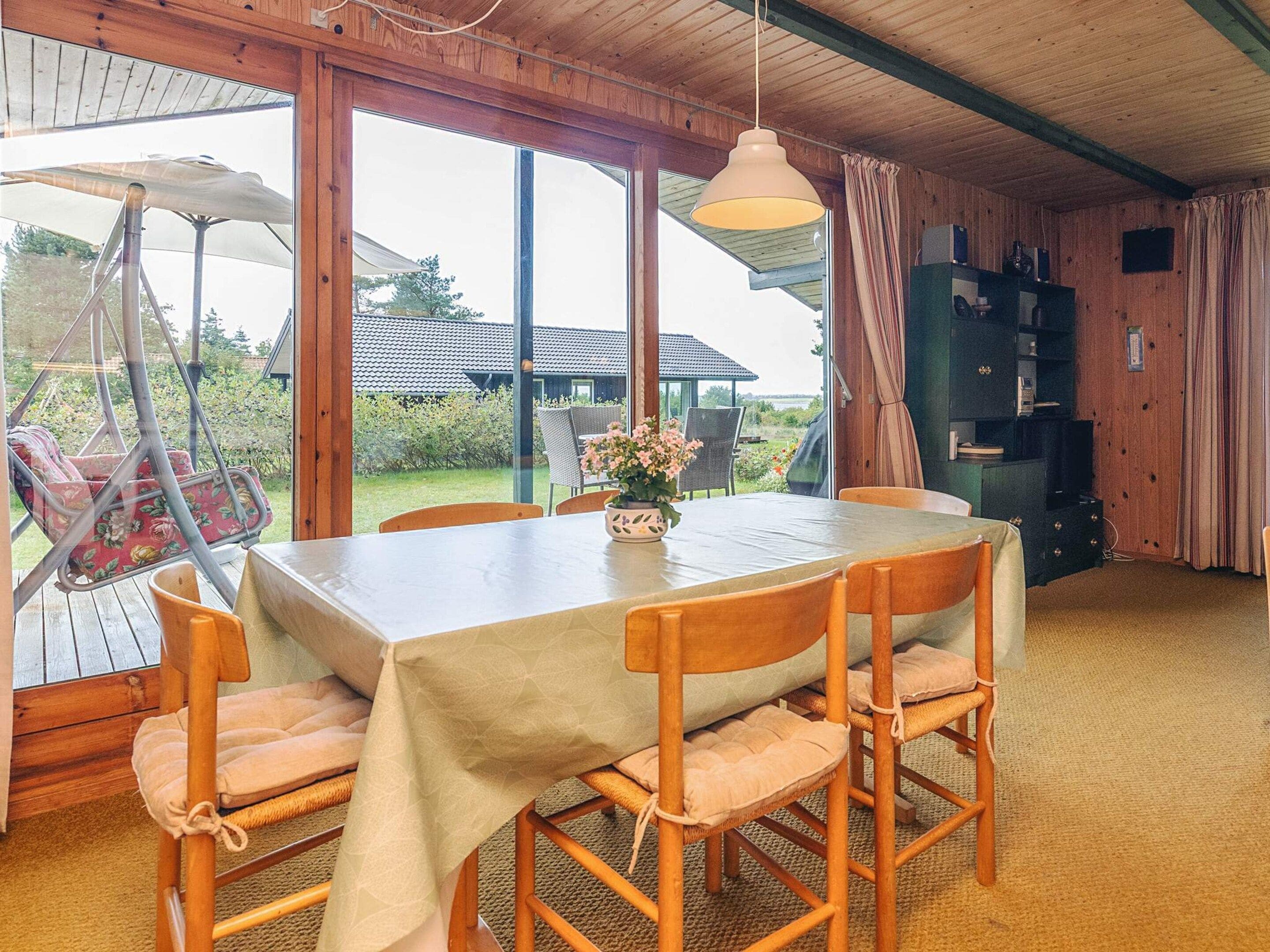 A dining area with a table, chairs, and a hanging chair.