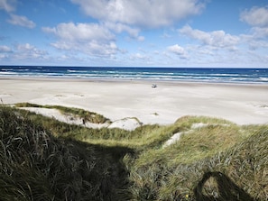 A beach with sand dunes and a vehicle on the beach. - 5 Star Holiday Home in Blokhus (Blokhus)