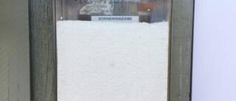 Une fenêtre recouverte de neige, sur laquelle on peut lire l’inscription « SOMMERHAUS ».