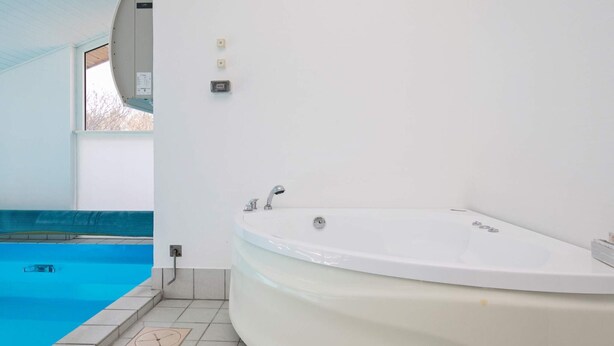 Casa de banho moderna com uma banheira grande, uma janela e uma piscina.