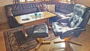 A cozy corner with a leather sofa, a wooden coffee table, and a matching ottoman. - 6 Person Holiday Home in Nordli (Lierne)