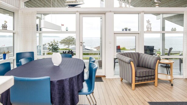 Une pièce spacieuse avec une grande table et des chaises, un canapé et une vue sur la mer.