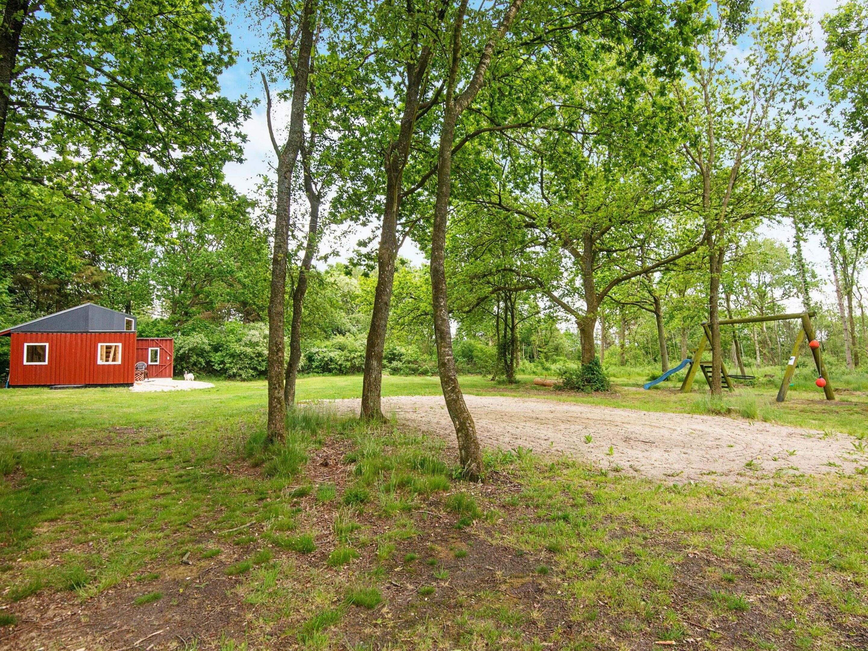 A red barn, a dirt path, and a playground with a swing set.