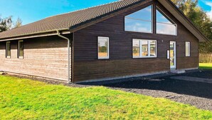 A two-story wooden building with a sloped roof, large windows, and a door. - 10 Person Holiday Home in Rodby-by Traum (Rodby)