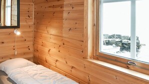 A single bed in a cabin with wooden walls and a window overlooking a rocky landscape. - Holiday Home in Selje (Stad)