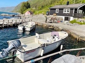 A boat docked at a pier with a house in the background. - Holiday Home in Selje (Stad)