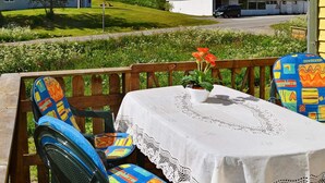 A patio with a table and chairs, a mountain view, and a building in the background. - 5 Person Holiday Home in Digermulen (Vagan)