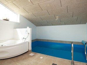 A bathroom with a bathtub, shower, and a window. - 5 Star Holiday Home in Juelsminde (Horsens)