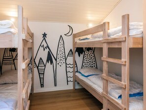 A bunk bed room with a mountain and moon mural on the wall.