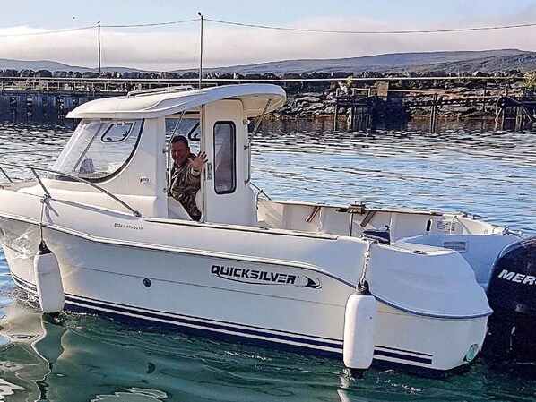 A white motorboat named QUICKSILVER docked at a pier with a rocky shoreline in the background. - 7 Person Holiday Home in Breivikbotn (Hasvik)