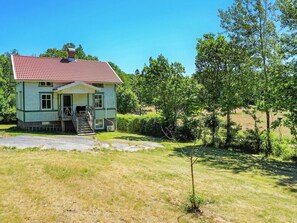 A two-story house with a red-tiled roof, a front porch, and a small front yard. - 5 Person Holiday Home in Kungshamn (Kungshamn)