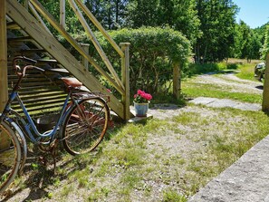 A rustic wooden staircase leading to a house, a rusty bicycle parked by the stairs, and a gravel path with a potted plant. - 5 Person Holiday Home in Kungshamn (Kungshamn)