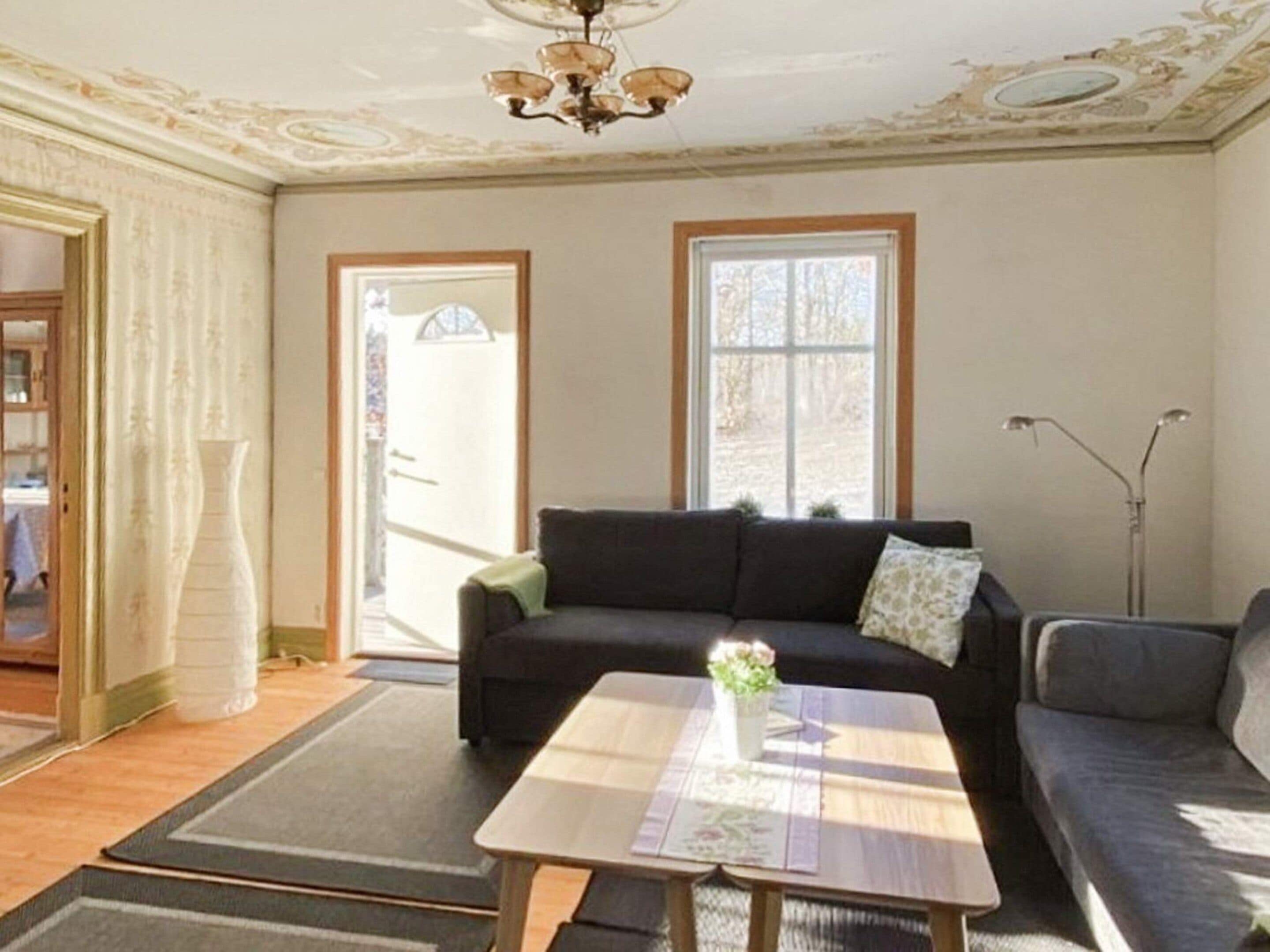 A living room with a sofa, a coffee table, and a chandelier.