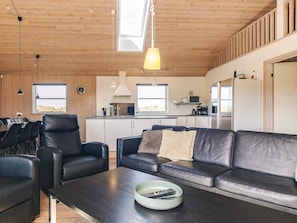 Ein modernes Interieur mit Essbereich, Sofa und Küche.