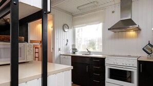 A compact kitchen with a microwave, coffee maker, sink, and stove.