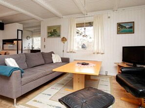 Una sala de estar acogedora con un sofá, una mesa de centro, un televisor y un comedor.