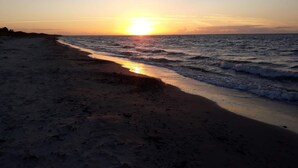 A beach with a sunset over the ocean.
