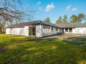 A two-story building with a covered patio and a grassy yard. - 18 Person Holiday Home in Romo (Rømø)