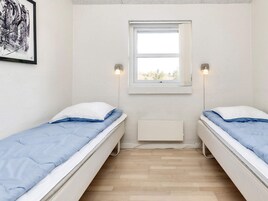 Una habitación con dos camas individuales, un ventanal con vistas y un radiador.