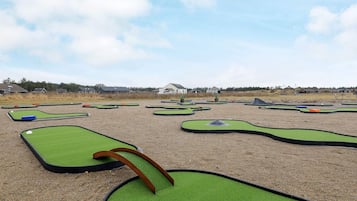 A miniature golf course with multiple green putting areas and a few obstacles.