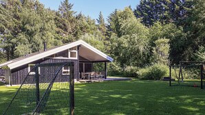 A residential property with a covered patio, a fenced play area, and a lawn. - 4 Star Holiday Home in Bindslev (Bindslev)