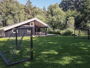 A residential property with a covered patio, a fenced play area, and a lawn.