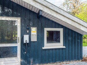 A building with a door, a window with a bicycle, and a DanCenter sign. - 4 Star Holiday Home in Bindslev (Bindslev)