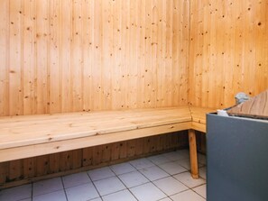 A wooden sauna with a bench and a small table. - 4 Star Holiday Home in Bindslev (Bindslev)