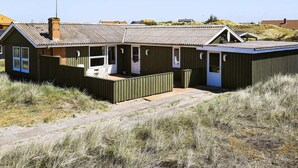 A coastal building with a large deck, a chimney, and a satellite dish. - 6 Person Holiday Home in Ringkobing (Ringkobing)