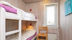 A bunk bed room with a desk and chair, wooden walls, and a window. - 6 Person Holiday Home in Ringkobing (Ringkobing)