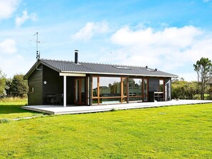 A modern house with a large glass door, a covered patio, and a chimney.