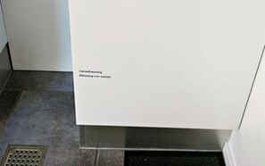 Et hvidt køkken med et rustfrit stål emhætte og en udluftning.
