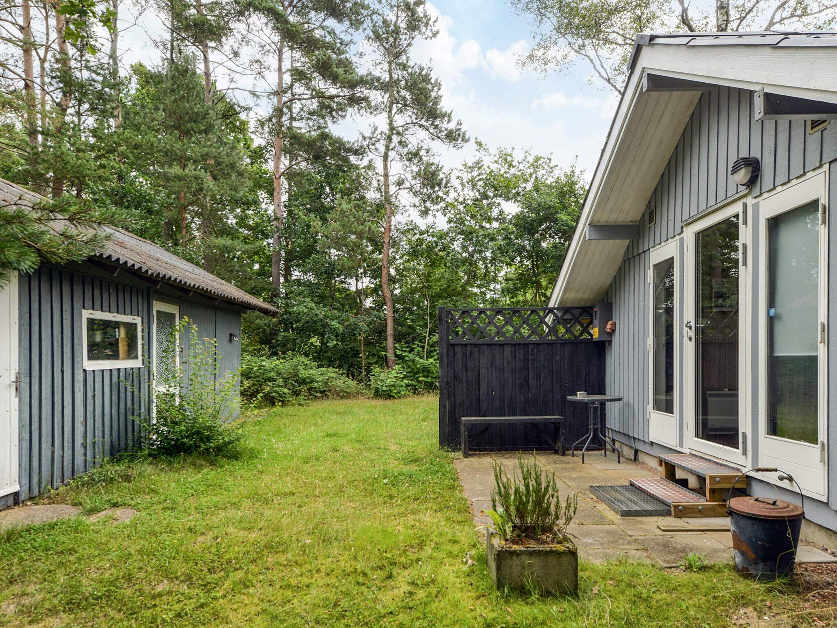 A residential property with a fenced backyard, a small shed, and a patio area with a table and chairs.
